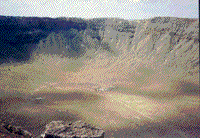 Color ground phototgraph from the rim of Meteor Crater looking down at the floor of the crater.