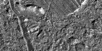 B/W image of the surface of Europa showing a chaos of small plates and wedges in an area known as Conamara Chaos.